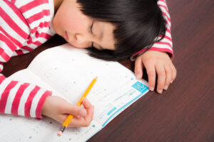 勉強の途中で居眠りしてしまった女の子の写真