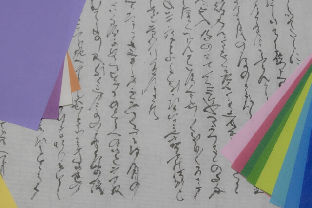 古文が書かれた和紙とカラフルな短冊が置かれた写真